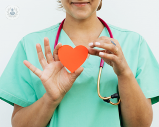 A woman holding a heart in front of her