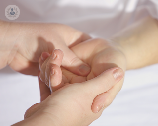 A person pressing a finger into the palm of another person's hand