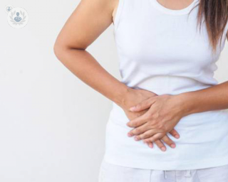 Woman in white in pain from gallbladder problems