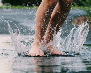 Teenager's feet splashing on water