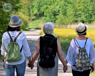 Three women holding hands. 