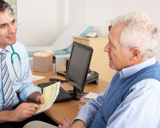 An elderly man talking with a doctor.