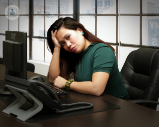 woman looking stressed at an office desk