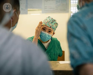 A surgeon explaining something to her colleagues 