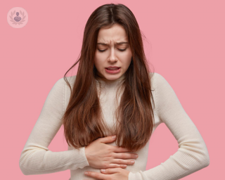 Young woman with gut health issues holding her stomach