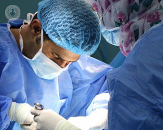 A picture of two surgeons performing liver surgery 