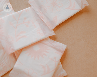 6 pink and white period pads laying on a surface