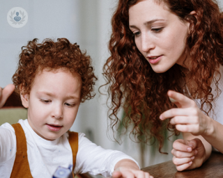Mother and son with red, curly hair sat at a table
