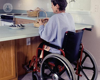 Woman in wheelchair at kitchen top 