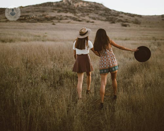 Two women in a field in coachella style outfits 
