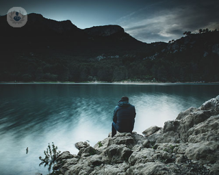 Man sitting looking at a lake