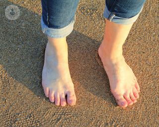 A pair of feet in the sand.