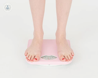Woman standing on pink scales 