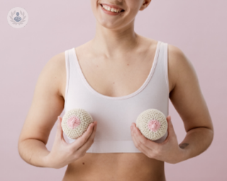 A picture of a woman holding knitted boobs