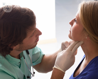 A surgeon checking a patient's neck. 