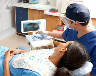 dentist assessing lady's teeth on x-ray