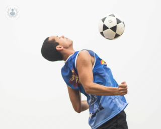 A picture of a man playing football, chesting the ball