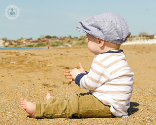 A baby sitting on a beach