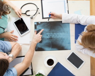 Health experts looking at a hip x-ray