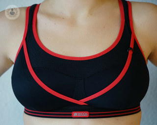 A woman's breasts in a black and red sports bra