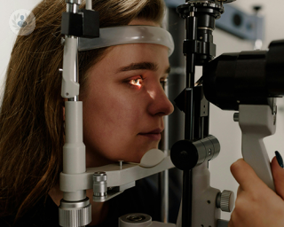 A young woman undergoing an eye examination of the front of her eyes.