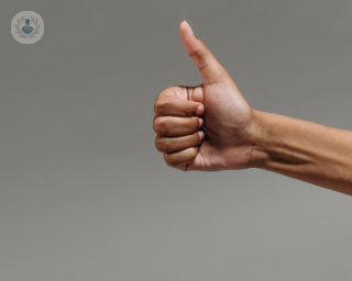 Man's olive skinned arm and hand in a thumbs up sign