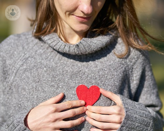A woman holding a paper heart