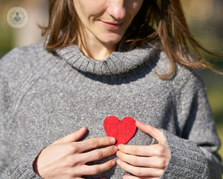 A woman holding a heart to her chest 