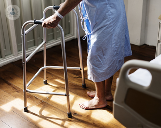Man wearing hospital gown and using a walker (Zimmer frame)