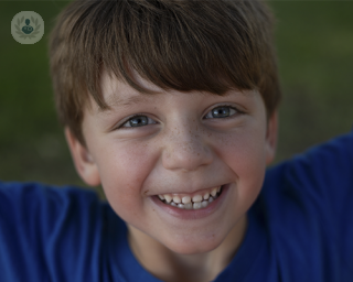 A picture of a young boy, about seven years old, looking up into the lens and smiling. The majority of adenoid problems occur during childhood.
