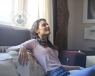 Woman sat on the sofa looking relaxed and relieved