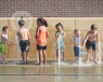 Six children play in a fountain