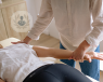 A physiotherapist stretching and treating a patient's shoulder and elbow joints.
