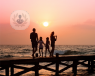 A picture of a family standing on a dock looking at sea