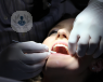 Woman in the dentist chair with her mouth open.