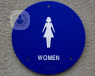 A blue sign signalling a women's toilet