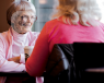 Pair of older ladies in a café talking and smiling