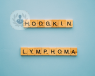 Scrabble letters spelling out Hodgkin lymphoma on a blue table