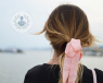 Girl looking into distance wearing a pink bow in her hair