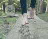 Woman's feet walking along a fallen tree