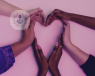 Lots of hands coming together forming the shape of a heart on a pink background