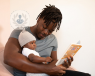 Father holding his baby and reading a story from a book