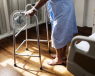 Man wearing hospital gown and using a walker (Zimmer frame)