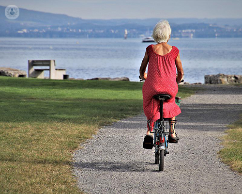 An old woman riding her bike.