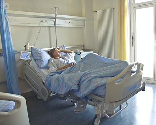 A photo of a woman lying in a hospital bed