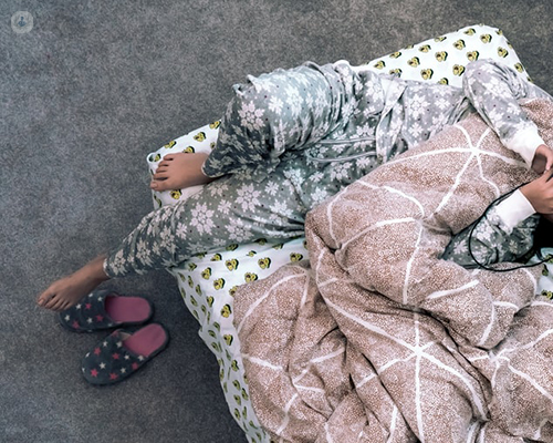 Girl in pyjamas lying on bed 