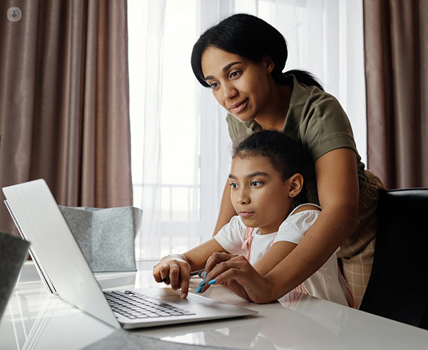 Mother and little girl working on laptop