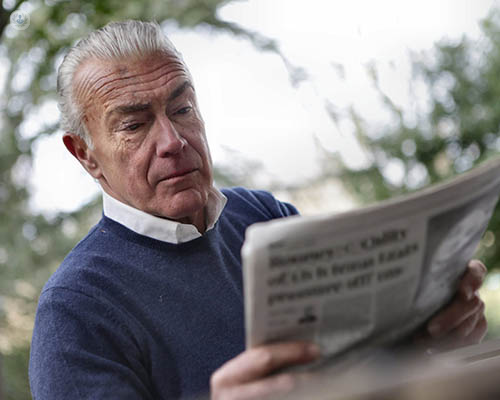 An older man reading a newspaper.