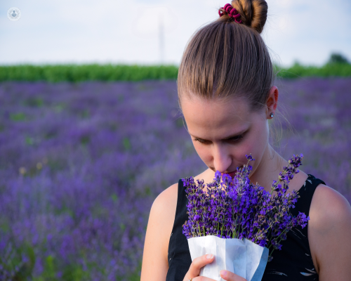 A woman smelling some flowers