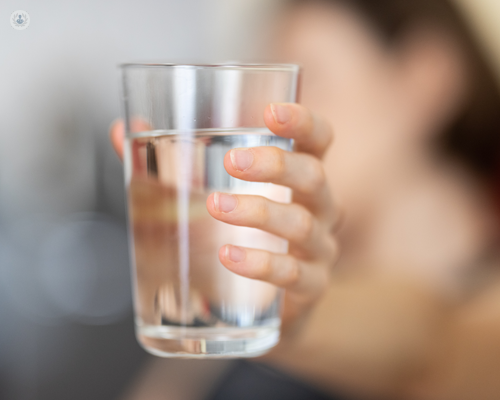 Glass of water used as part of colonoscopy preparation, with a laxative